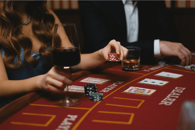 woman and man playing baccarat in a casino
